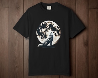 May include: Black t-shirt featuring a detailed illustration of a howling wolf in front of a full moon. The wolf is depicted in shades of gray and white, with the moon in a contrasting black and white. The shirt is made of a soft material.