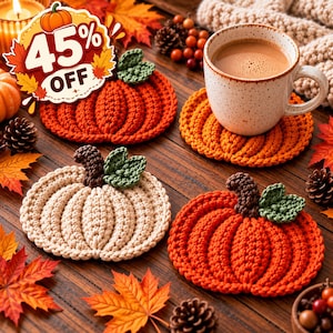 May include: Three crocheted pumpkin-shaped coasters in orange and cream colours, each featuring a dark brown stem and two green leaves. One coaster supports a speckled ceramic mug filled with a light brown beverage, while a 45% off graphic is visible.