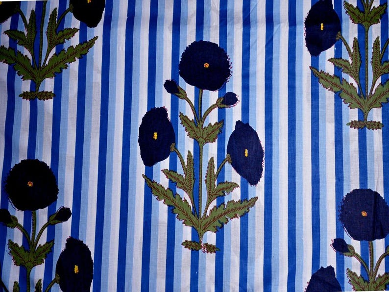May include: Textile with a blue and white striped background. Dark blue floral pattern with yellow centers and green leaves. The design is repeated across the fabric, creating a visually appealing pattern.