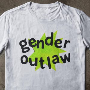 May include: A white ceramic mug with a black handle and the text "But First, Coffee" in a handwritten style. The mug is on a white surface. The mug is approximately 4 inches tall.