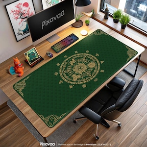 May include: A green desk mat with a gold circular design and decorative borders. The mat, measuring 23.6" x 47.2", is placed on a wooden desk with a computer, keyboard, and mouse. The word "Pixavaa" is visible on the computer screen.