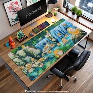 May include: A large rectangular desk mat featuring a vibrant waterfall scene with cartoon Psyduck characters. The mat, measuring 60 x 120cm, has a colorful design with the Pixavaa logo on the bottom. A computer, keyboard, and mouse are on the desk.
