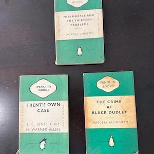 Puede incluir: Tres libros Penguin Books vintage con cubiertas verdes. Los títulos incluyen "Miss Marple and the Thirteen Problems" de Agatha Christie, "Trent's Own Case" y "The Crime at Black Dudley". Cada libro presenta un logotipo de pingüino.