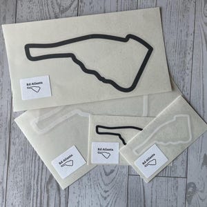 May include: Several vinyl stickers featuring a black outline of a hand with a pointed finger. Each sticker has a small white label with the text "Rd Atlanta" and a matching hand outline. The stickers are on a light background.