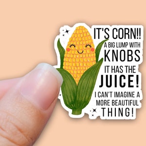 May include: A sticker featuring a cartoon corn cob with a smiling face and the text "IT'S CORN!! A BIG LUMP WITH KNOBS IT HAS THE JUICE! I CAN'T IMAGINE A MORE BEAUTIFUL THING!"