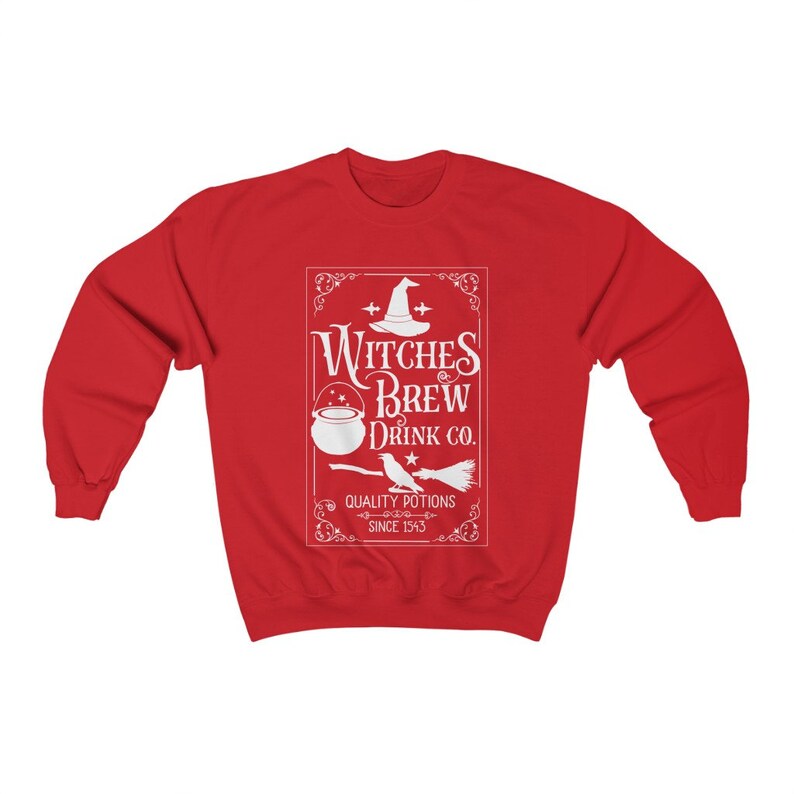 May include: A red sweatshirt featuring a white graphic with the text "Witches Brew Drink Co." and illustrations of a witch's hat, cauldron, bird, and broom. The text "Quality Potions Since 1543" is also included.