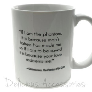 May include: White ceramic coffee mug with a black quote from Gaston Leroux's "The Phantom of the Opera": "If I am the phantom, it is because man's hatred has made me so. If I am to be saved it is because your love redeems me."