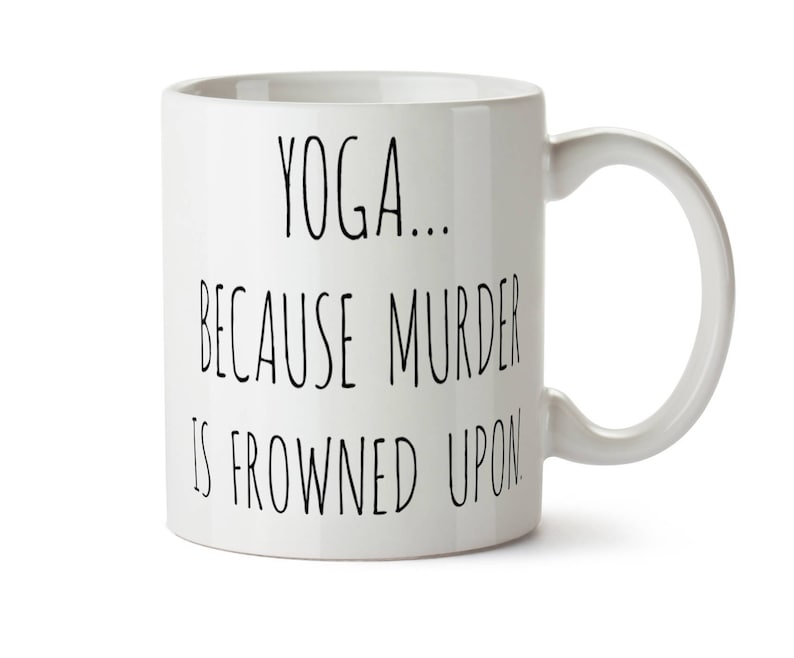 May include: White ceramic mug with a curved handle. The mug features black text that reads "YOGA... BECAUSE MURDER IS FROWNED UPON."