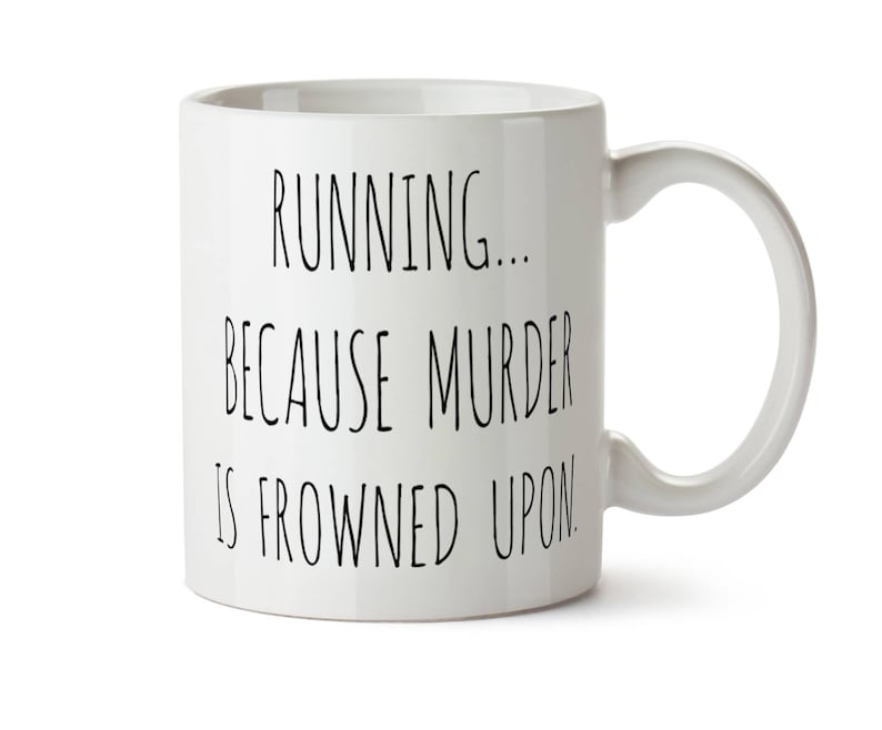 K&ouml;nnte beinhalten: Wei&szlig;e Keramik-Kaffeetasse mit schwarzem Text, der "Running... Because murder is frowned upon." lautet.