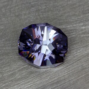 May include: A faceted purple gemstone with a star-like pattern in the center.