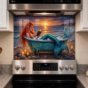 May include: A kitchen splashback panel featuring a vibrant illustration of a red-haired mermaid sitting in a teal clawfoot bathtub on a beach at sunset, reading a book. The scene includes glowing candles, seashells, and a wine glass on the sand.