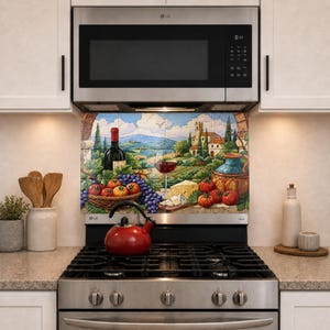 May include: A stainless steel gas range with a red tea kettle on the stovetop and a decorative tile backsplash featuring a painted landscape of a vineyard, wine bottle, glass of red wine, grapes, tomatoes, and cheese under an LG microwave.