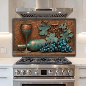 May include: A copper-toned wall art piece with a wine theme. It depicts a wine bottle, a glass, and a bunch of grapes in teal and copper shades. The artwork is mounted above a stainless steel cooker.