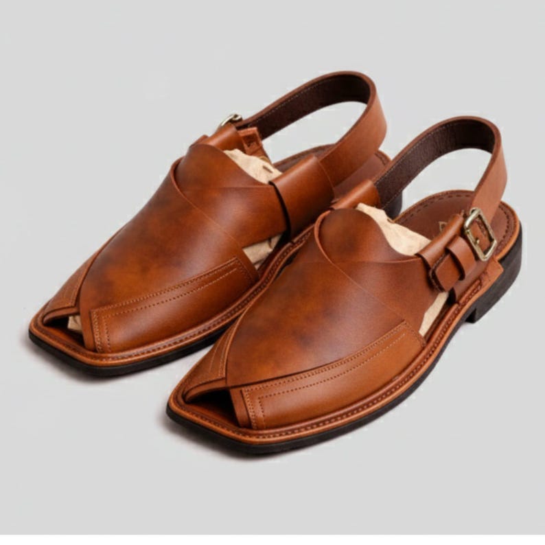 May include: A pair of brown leather sandals with a square toe design. The sandals have a strap that goes around the ankle and a buckle closure. The leather has a textured appearance and a dark brown sole.