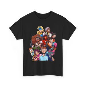 Könnte beinhalten: Schwarzes T-Shirt mit einer farbenfrohen Grafik, die eine Gruppe von Cartoon-Charakteren zeigt. Die Illustration zeigt eine vielfältige Gruppe von Personen mit unterschiedlichen Hauttönen, Haarfarben und Stilen. Die Charaktere sind eng beieinander angeordnet und erzeugen ein Gefühl der Gemeinschaft.