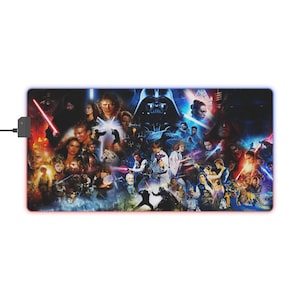 Peut inclure: Tapis de souris rectangulaire avec un collage de personnages et de scènes de Star Wars. Le tapis a une bordure noire avec une lumière bleue et rouge. Un câble USB et un adaptateur secteur sont attachés.