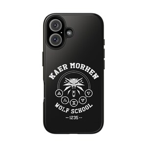 May include: Black phone case featuring the text "KAER MORHEN" and "WOLF SCHOOL" in white, along with a wolf emblem. The case also includes the number "-1235--". The phone case has a camera and flash.