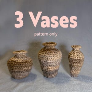 May include: Three crocheted vases in varying sizes, displayed against a gray backdrop. The vases are crafted with a textured, neutral-toned yarn, showcasing a handmade aesthetic. The text "3 Vases pattern only" is displayed above the vases.