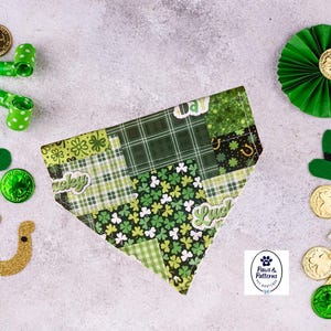 May include: A St. Patrick's Day themed dog bandana with a patchwork design of green shamrocks and plaid patterns. The image includes green decorations like hats, coins, and shamrocks.