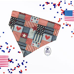 Peut inclure: Un bandana pour chien patriotique avec un motif patchwork de stars, de rayures et de cœurs rouges, blancs et bleus. Le bandana est entouré de confettis et de petits drapeaux américains.