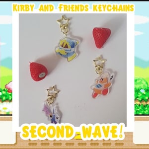Op de afbeelding: Afbeelding toont sleutelhangers met Kirby en Friends-personages, waaronder een aardbei en andere karakterontwerpen. De tekst "Kirby and Friends Keychains" en "Second Wave!" worden weergegeven.