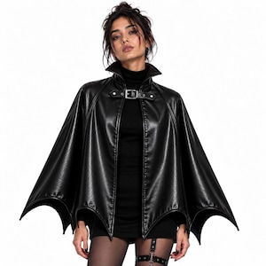 Gothic vampire batwing cape worn by woman, black leather cloak with high collar and buckle closure for Halloween costume