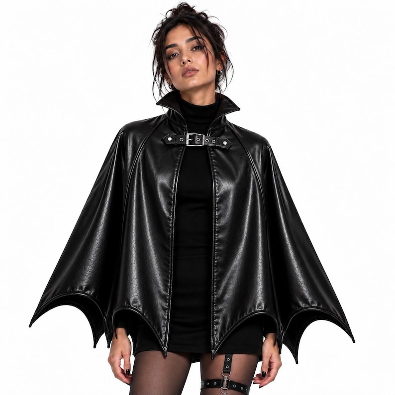 Gothic vampire batwing cape worn by woman, black leather cloak with high collar and buckle closure for Halloween costume