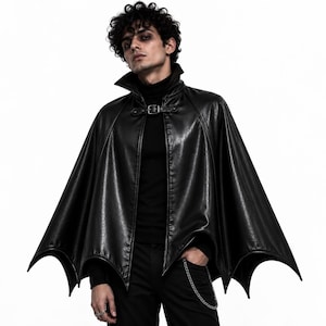 Man wearing black gothic vampire batwing cape with high collar, front buckle and dramatic Halloween cosplay look