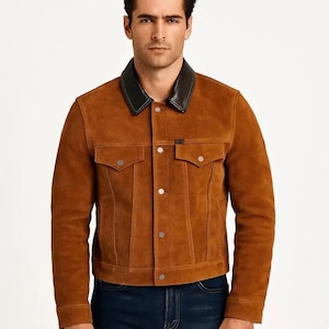 May include: A brown suede jacket with a black leather collar. The jacket has two chest pockets, silver buttons, and a classic design. The jacket is a medium brown color and is made of suede material.
