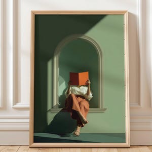 May include: Framed art print featuring a person seated in a window reading a book. The person is wearing a white shirt and rust-colored pants. The book is orange, and the wall is green. The frame is light wood.