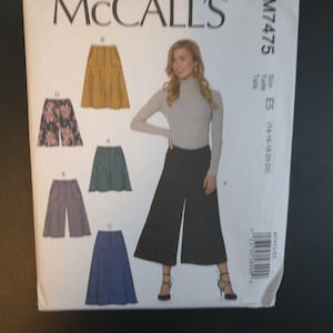 May include: A McCall's sewing pattern envelope, M7475, featuring illustrations of various skirt and pants designs. The envelope shows a woman wearing black culottes. The size is E5 (14-16-18-20-22).