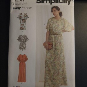 May include: Simplicity sewing pattern featuring a woman in a floral print dress. The pattern includes multiple dress styles, with the text "easy-to-sew" and size information. The pattern is printed in the USA.