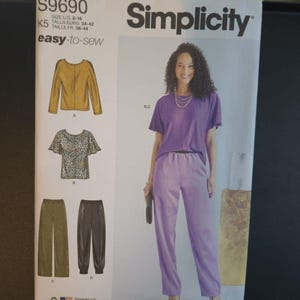 May include: Simplicity sewing pattern S9690, featuring a woman in a purple outfit. The pattern includes illustrations of tops and pants. The text "easy-to-sew" is displayed on the pattern.