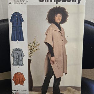 May include: A Simplicity S9649 sewing pattern envelope featuring a hooded cape with a button front and two large patch pockets. The cover displays three variations of the garment in blue, grey, and orange, alongside a model wearing the beige version.