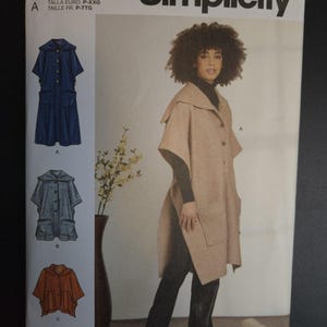 May include: Simplicity sewing pattern S9649 featuring a woman wearing a tan cape with large pockets. The pattern includes illustrations of different cape styles and the text "easy-to-sew".