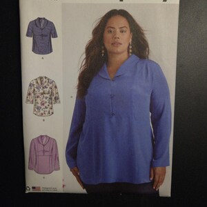 May include: Simplicity sewing pattern S9890 featuring a woman wearing a long-sleeved blue blouse. The pattern includes illustrations of different blouse styles. The text "Simplicity" is at the top.