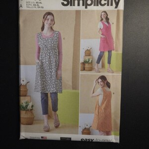 May include: Simplicity sewing pattern S9766 featuring three apron designs. The pattern includes sizes XS-XL. The cover shows women wearing the aprons in different colors and patterns. The text "easy-to-sew" is visible.