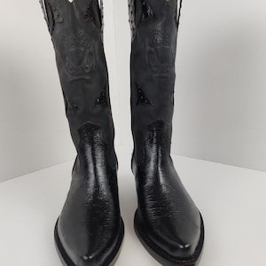 A pair of black leather cowboy boots with decorative elements on the sides.
