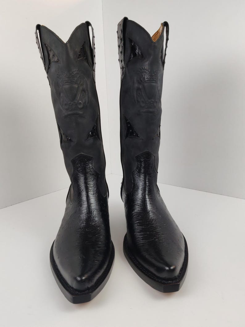 A pair of black leather cowboy boots with decorative elements on the sides.