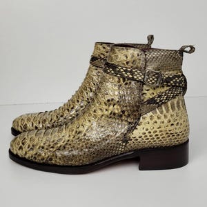 Puede incluir: Botines con estampado de piel de serpiente en tonos beige, marr&oacute;n y crema. Los botines tienen un tac&oacute;n bajo y una correa con hebilla alrededor del tobillo. Los botines est&aacute;n hechos de un material texturizado. Miden unos 10 cm de alto.