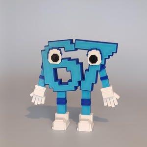 Pode incluir: Uma figura impressa em 3D do n&uacute;mero 67, em estilo pixelizado. A figura &eacute; azul clara com detalhes em azul escuro, luvas brancas e sapatos brancos. Os olhos s&atilde;o pretos com contornos brancos. A figura tem bra&ccedil;os e pernas.