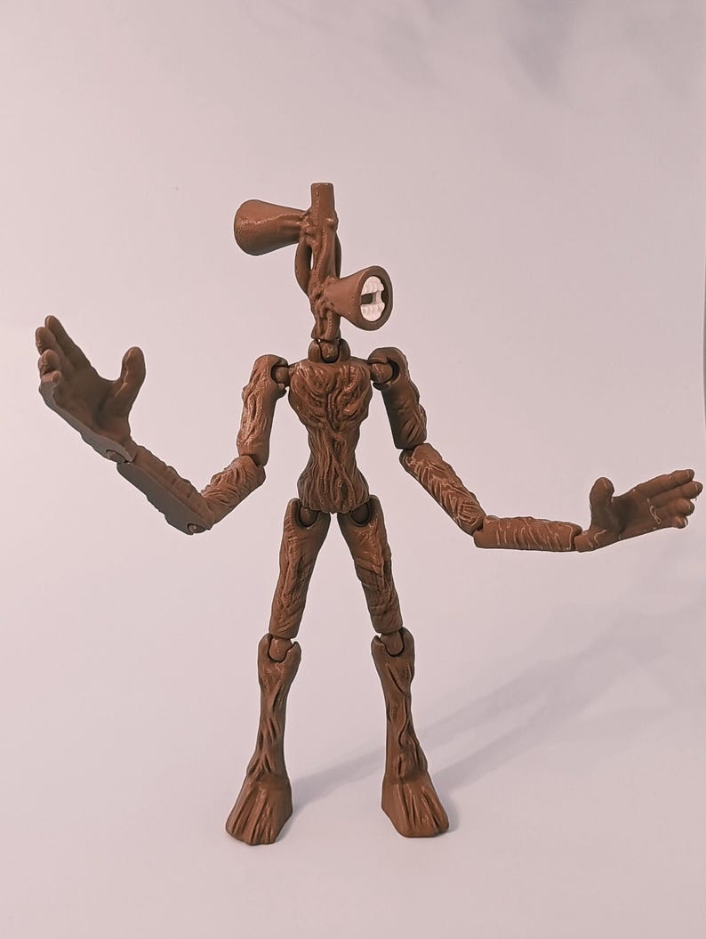 Op de afbeelding: Een bruin Siren Head actiefiguur met beweegbare gewrichten. De figuur heeft een uniek ontwerp, met een hoofd in de vorm van een paar luidsprekers en lange armen. De figuur poseert met uitgestrekte armen, waarbij het gedetailleerde, getextureerde oppervlak wordt getoond.
