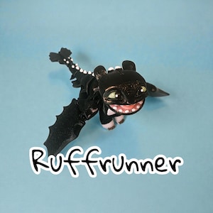 May include: A black dragon figurine with a smiling face, green eyes, and white teeth. The dragon has outstretched wings and a long tail with white spots. The word "Ruffrunner" is written in white script below the dragon against a blue background.