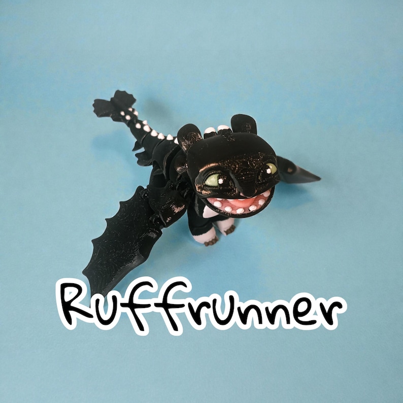 May include: A black dragon figurine with a smiling face, green eyes, and white teeth. The dragon has outstretched wings and a long tail with white spots. The word "Ruffrunner" is written in white script below the dragon against a blue background.