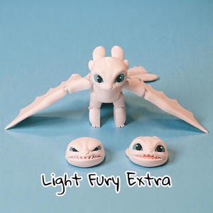 May include: A white Light Fury dragon figure with blue eyes and articulated wings. Two additional interchangeable heads are included, each with a different expression. The text "Light Fury Extra" is displayed below the dragon.