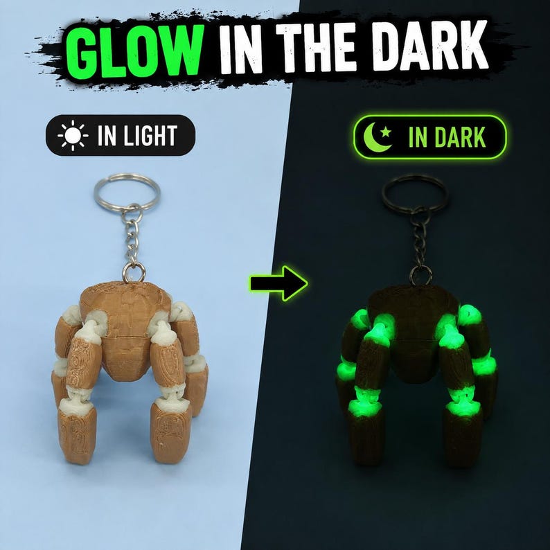 May include: A brown and white articulated spider keychain with a metal ring. The text GLOW IN THE DARK appears at the top, with IN LIGHT and IN DARK labels. The spider appears brown in light and emits a bright green glow in the dark.