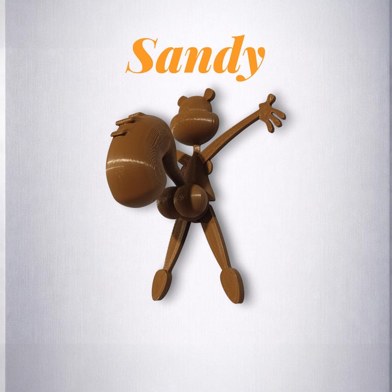 Puede incluir: Una figura de madera marr&oacute;n de un personaje de dibujos animados con un saco grande, los brazos extendidos y la palabra "Sandy" en escritura naranja arriba. La figura tiene una cabeza de oso y un dise&ntilde;o caprichoso.