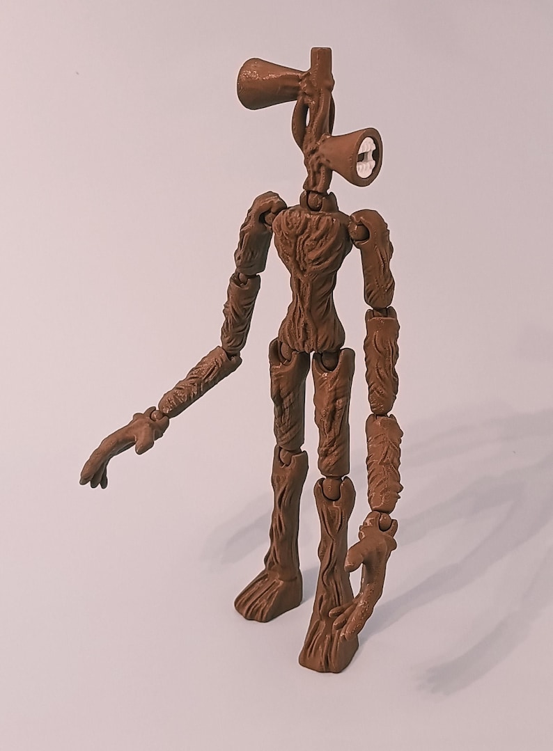 Op de afbeelding: Een bruin Siren Head actiefiguur met een getextureerd, boomachtig uiterlijk. Het figuur heeft twee luidspreker-vormige hoofden en beweegbare ledematen. Het figuur staat op een witte ondergrond.