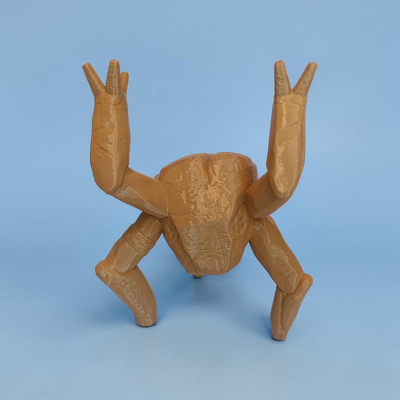 Pode incluir: Escultura impressa em 3D de cor castanha clara de uma criatura com quatro pernas e dois bra&ccedil;os levantados. A escultura tem uma superf&iacute;cie texturizada sobre um fundo azul claro.
