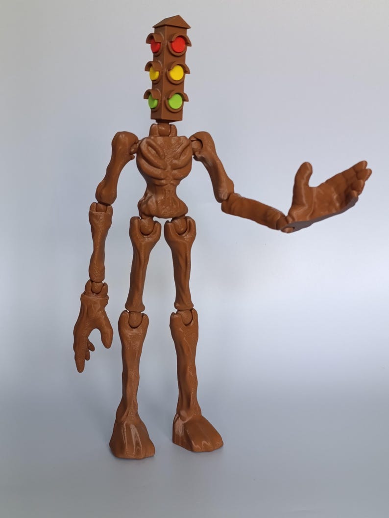 May include: A brown articulated figure with a traffic light head. The traffic light has red, yellow, and green lights. The figure has outstretched arms and a skeletal torso and limbs. The figure is standing on a white surface.